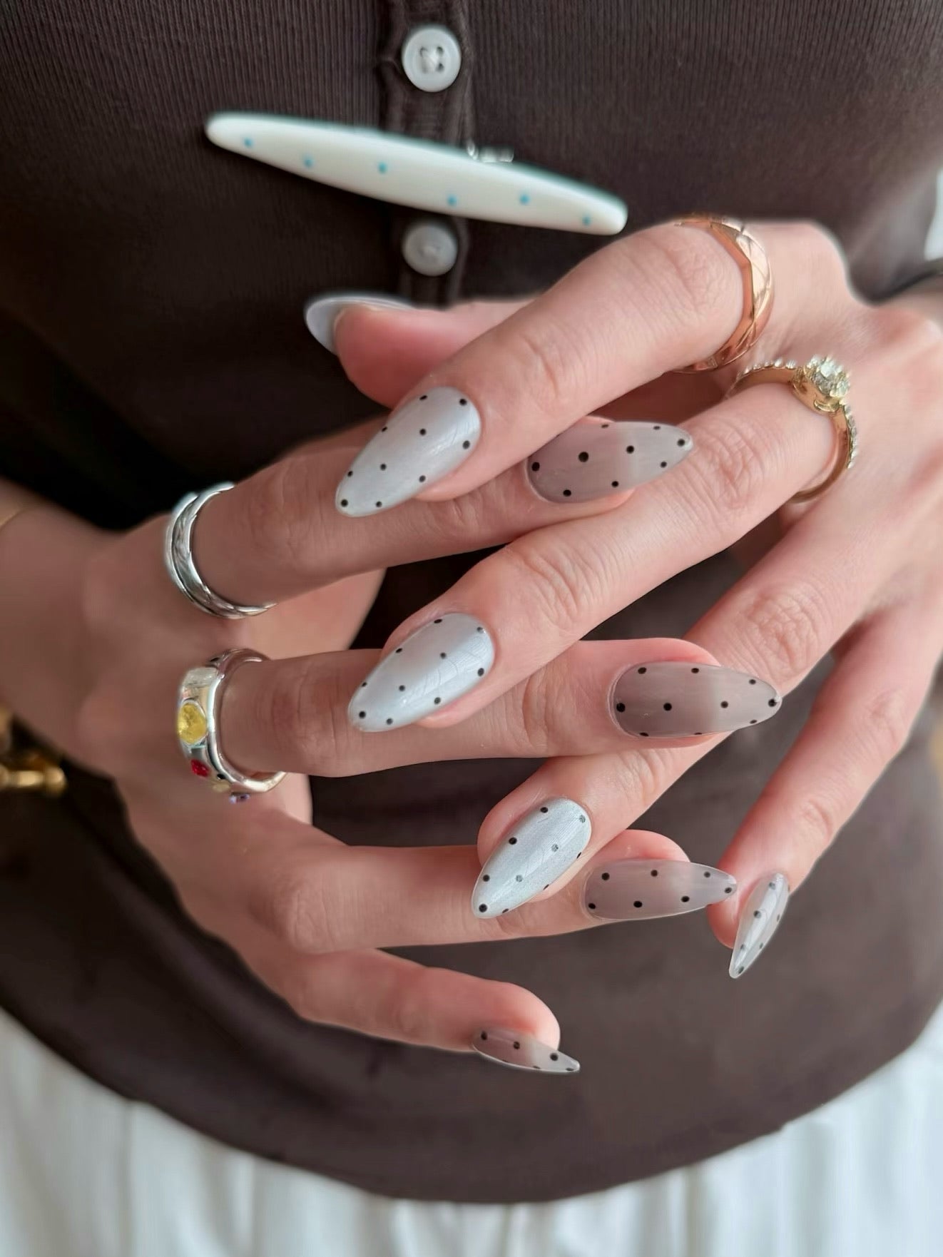 White press on nails with black dot nail art in almond shape