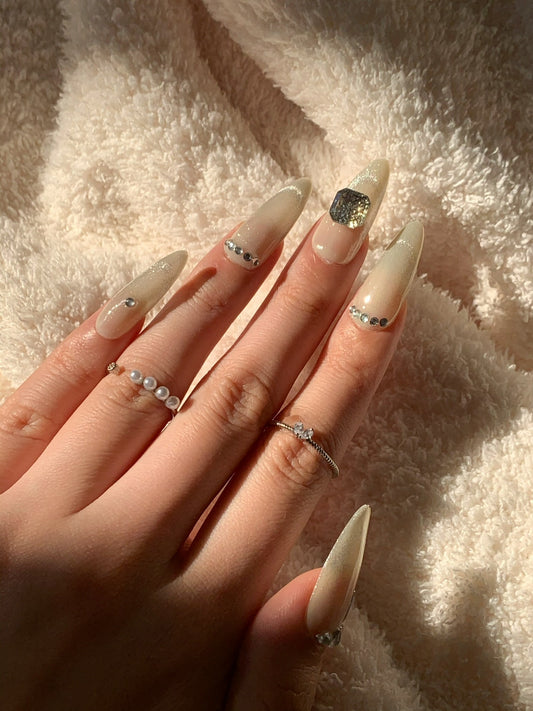 green almond nails with crystal accents